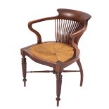 An Edwardian mahogany office desk armchair in the manner of Shoolbred, of tub-shaped outline,