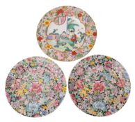 A pair of Chinese famille noire milliefleur plates painted with flowers and foliage on a black