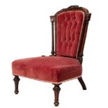 A Victorian carved walnut and pink velvet button upholstered nursing chair,