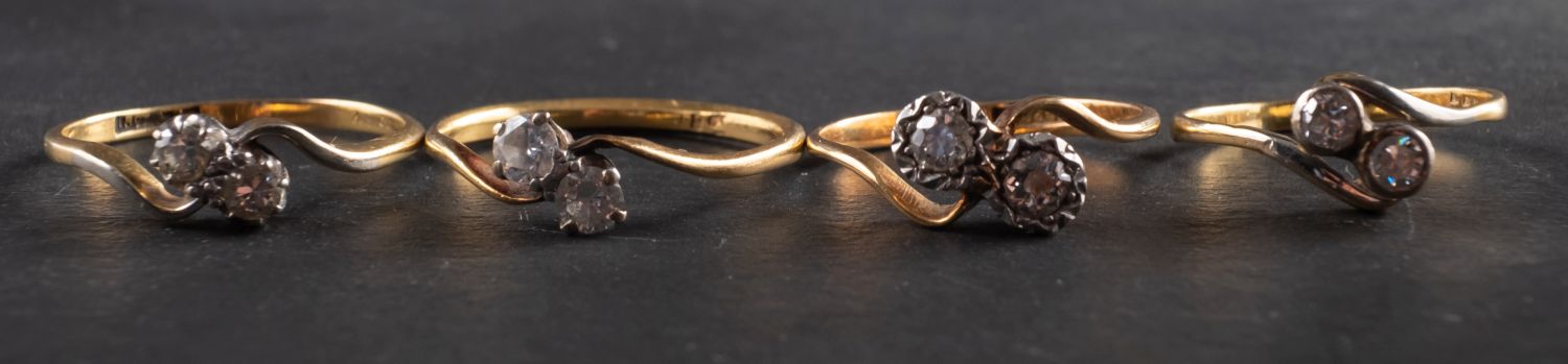Four diamond crossover rings, including a ring marked '18CT & PLAT',