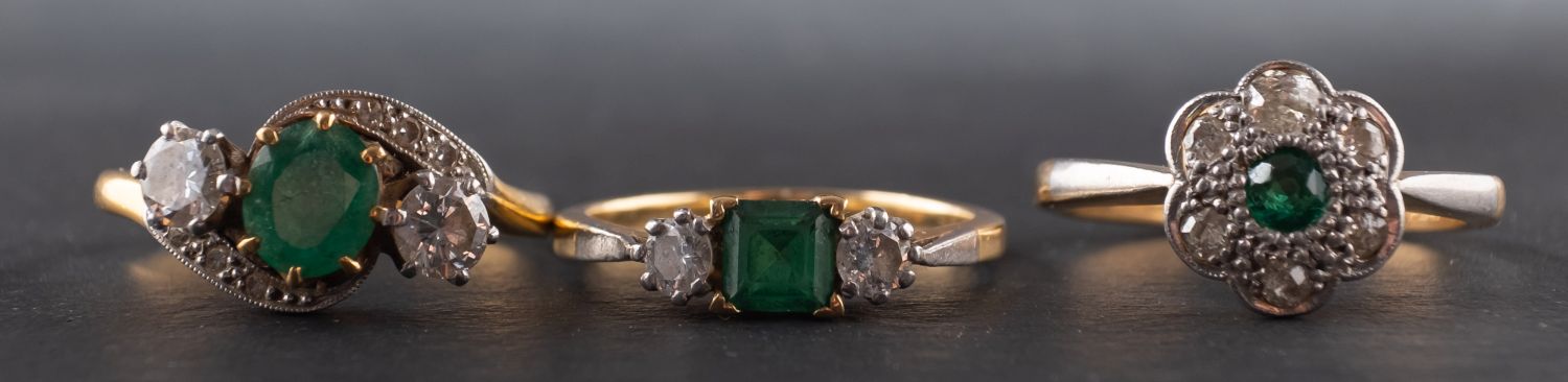 Three gemset rings, including an emerald and diamond three-stone ring marked '18CT & PLAT',