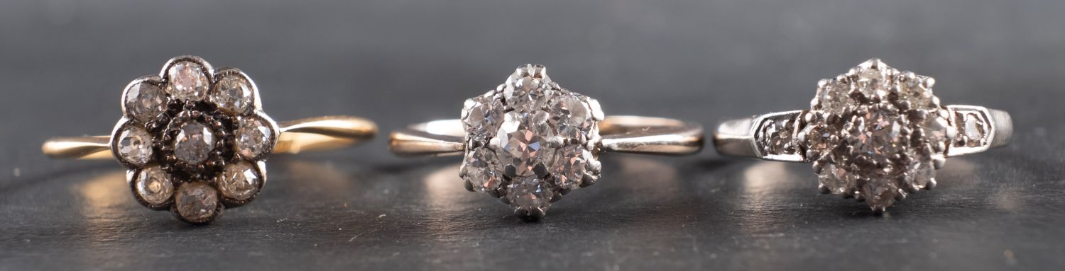 Three diamond cluster rings, including an 18ct gold ring, total estimated diamond weight ca. 0.