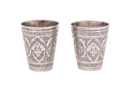 Two Persian silver tots of cylindrical tapering outline, with chased foliate decoration, 4.