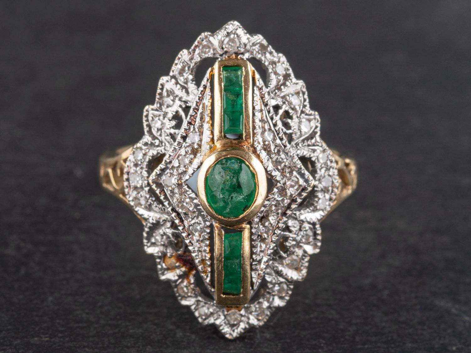 A calibre and cabochon-cut emerald and single-cut diamond ring, of navette design,