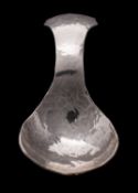 An Arts and Crafts hammered caddy spoon, white metal, with flared handle, stamped KSIA, 8cm long.