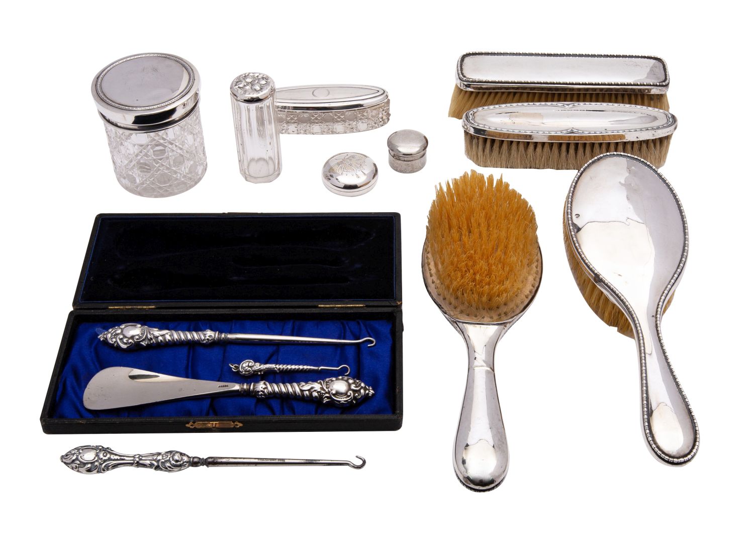 A George V matched silver dressing table set; comprising a pair of silver backed brushes,