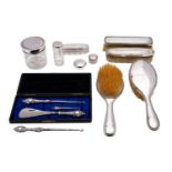 A George V matched silver dressing table set; comprising a pair of silver backed brushes,