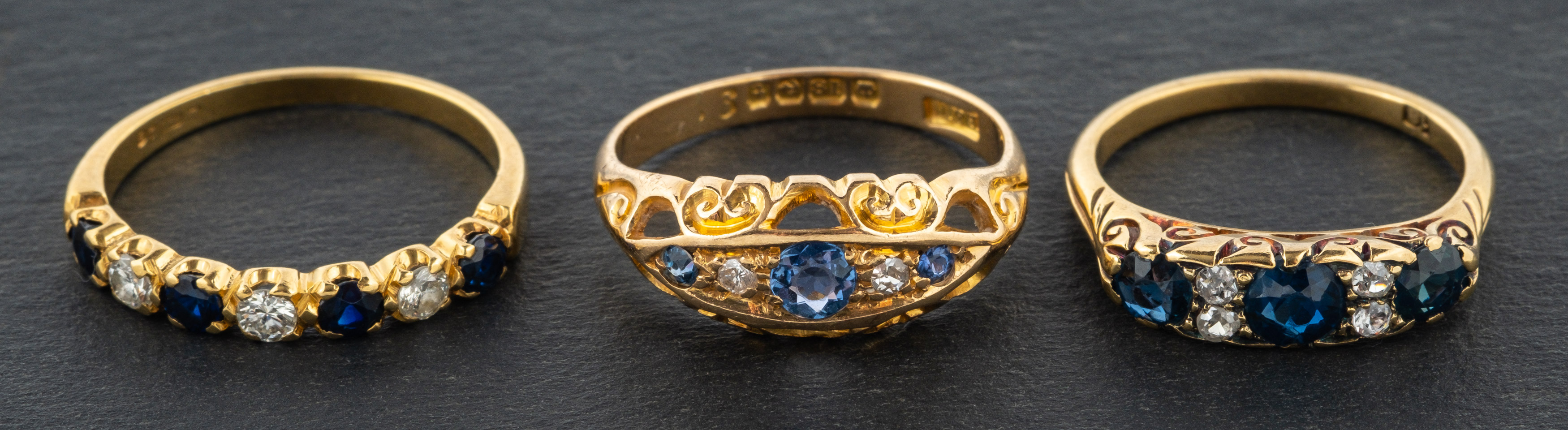 Three gemset rings, including an 18ct gold, sapphire and diamond half eternity ring,