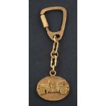 An oval keyring with applied decoration depicting a classic car,