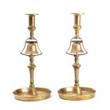 A pair of 19th century brass tavern service candlesticks: the plain sconces over a lever operated