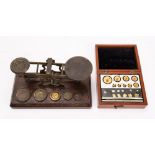 A set of Edwardian brass postal scales and five graduated weights,