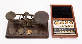 A set of Edwardian brass postal scales and five graduated weights,