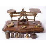 A set of early 20th century mahogany and brass postal scales and weights.