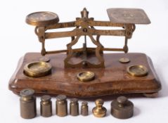 A set of early 20th century mahogany and brass postal scales and weights.