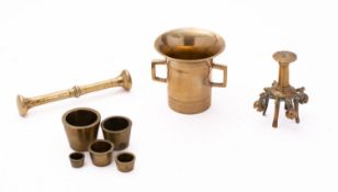 A part set of late 19th century concentric weights, together with a brass pestle and mortar,