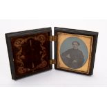 Victorian Photography, a cased hand tinted ambrotype portrait of a seated gentleman,