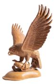 A carved beechwood group of a bird of prey with a fish, by Les Jewell,