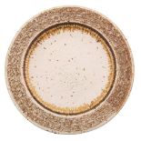 A grogged stoneware charger, with deeply textured border under ivory glazes and a flown russet band,