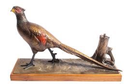 An Austrian cold painted spelter table lighter modelled as a pheasant beside a tree stump,