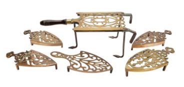 A Victorian brass and iron kettle trivet, together with five various brass iron trivets.