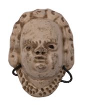 A small Staffordshire saltglaze mask of a child formally probably part of a pew group,