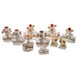 A group of eight Staffordshire swan inkwells and spill vases together with a pair of models of cats,