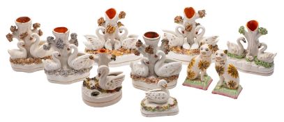 A group of eight Staffordshire swan inkwells and spill vases together with a pair of models of cats,