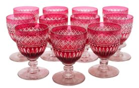 A set of eleven cranberry and clear wine glasses and a part suite of twelve wine glasses,