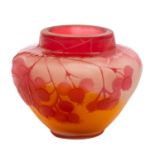 A small Gallé cameo glass vase decorated in red with gooseberries and foliage on an orange and
