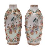 A pair of Chinese famille rose relief-moulded vases painted with cartouches of elegant ladies and