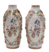 A pair of Chinese famille rose relief-moulded vases painted with cartouches of elegant ladies and