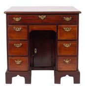 A George III mahogany kneehole desk, the rectangular top with rounded corners and a moulded edge,