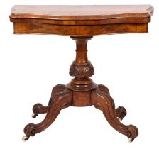 A Victorian walnut card table of serpentine outline;