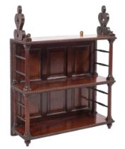 An early 19th Century mahogany three tier hanging bookcase with fret carved stylised foliate