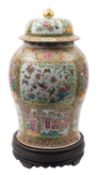 A large Chinese Canton famille rose baluster jar and domed cover painted with panels depicting