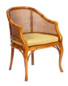 A beechwood tub shaped bergere armchair in Regency style,