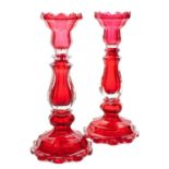 A pair of Bohemian ruby and clear glass candlesticks of faceted baluster form,