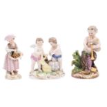 A group of three Meissen figures comprising an 18th Century group of cherub traders with bolts of