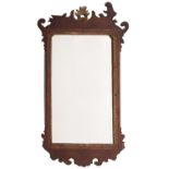 A 19th century walnut fret carved and parcel gilt wall mirror; with a rocaille cresting,