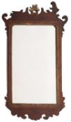 A 19th century walnut fret carved and parcel gilt wall mirror; with a rocaille cresting,