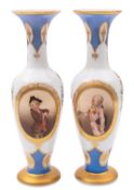A pair of French opaline glass vases painted with pendant floral sprays and oval panels of young