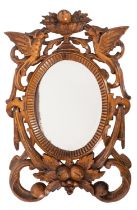 An Italian carved wood wall mirror, 20th century; the oval bevelled plate in a carved surround,