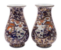 A pair of Japanese Imari vases of inverted pear shape painted with panels of lake side scenes