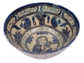 A Persian pottery bowl decorated in blue and grey with bands and panels of portraits,