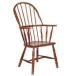 A 19th-century elm and ash stick back Windsor elbow chair; with a shaped solid seat,