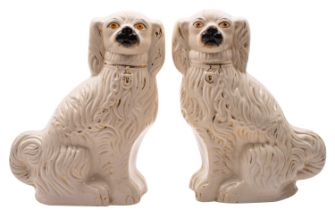 A pair of large late C19th Staffordshire pottery figures of spaniels with painted muzzles and eyes,