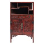 A Chinese red lacquered side cabinet, 20th century; with an arrangement of open shelves above,