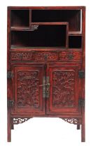 A Chinese red lacquered side cabinet, 20th century; with an arrangement of open shelves above,