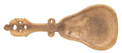An Inuit carved reindeer horn spoon; the pear-shaped bowl with incised decoration of a reindeer,
