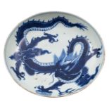 A Chinese blue and white 'dragon' saucer dish the interior painted with a dragon clasping a sacred